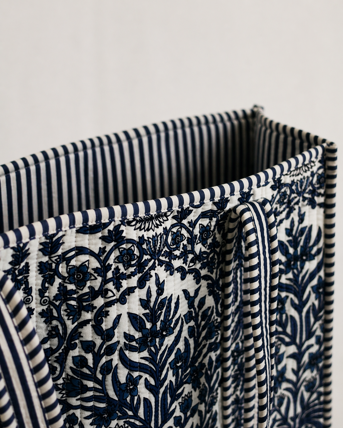 Stack of fabric with blue and white patterns on a light gray background